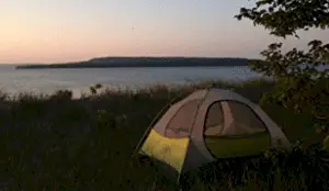 tent in grass by lake