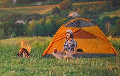 girl camping by camp fire