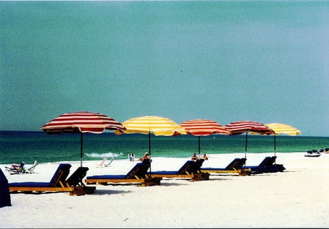 line five beach umbrellas over chairs