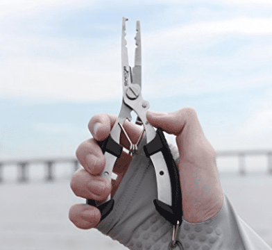 gloved hand holding fishing pliers