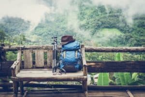 blue backpack hiking poles on bench