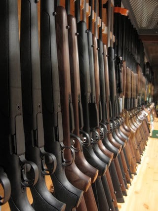 line of shotguns in standing in case