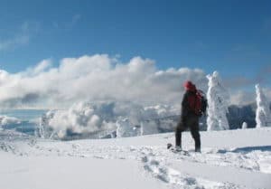 man snowshoeing on snowy mountain