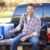 angler sitting on truck bed with cooler
