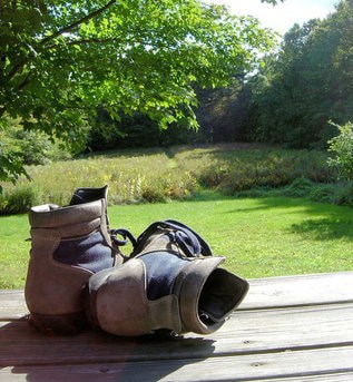 hiking boots on porch overlooking country