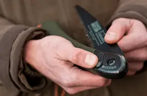 hands opening folding saw