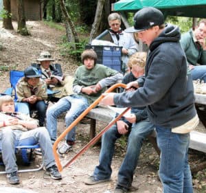 Boy scouts learning about bow saw at camp