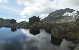 hut shelters by lake and mountain