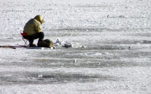 Ice fisherman over fishing hole