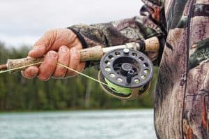 fly fisher holding rod