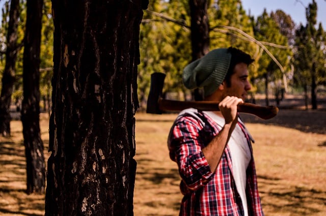 lumberjack holding ax in woods
